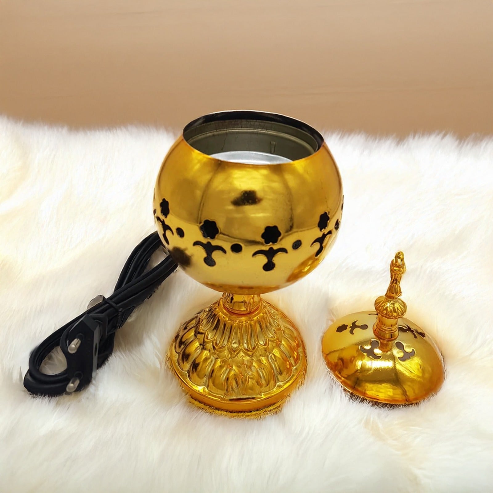 Luxurious golden electric bakhoor burner on soft white fur background