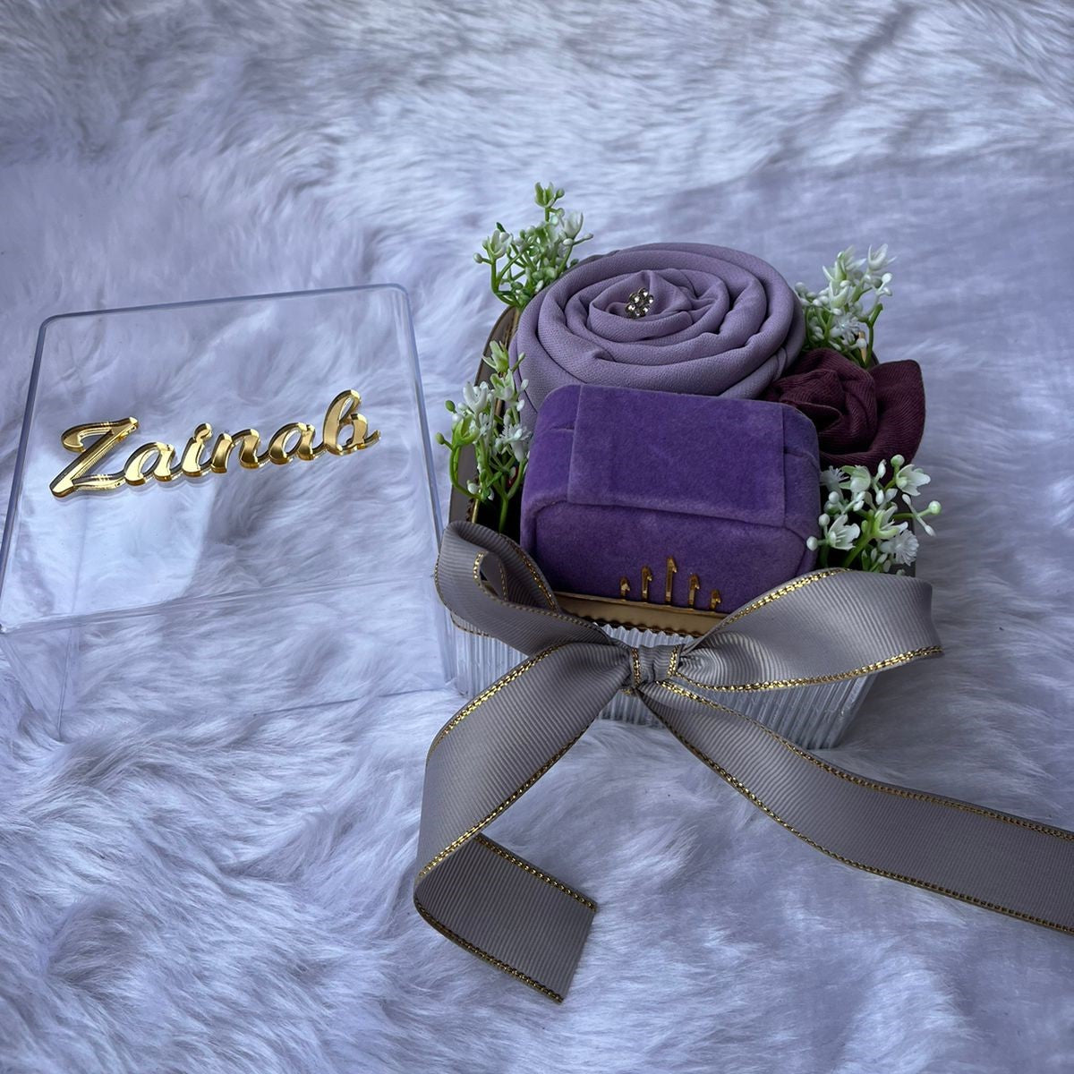 Elegant abaya gift box with purple fabric and gold-accented ribbon