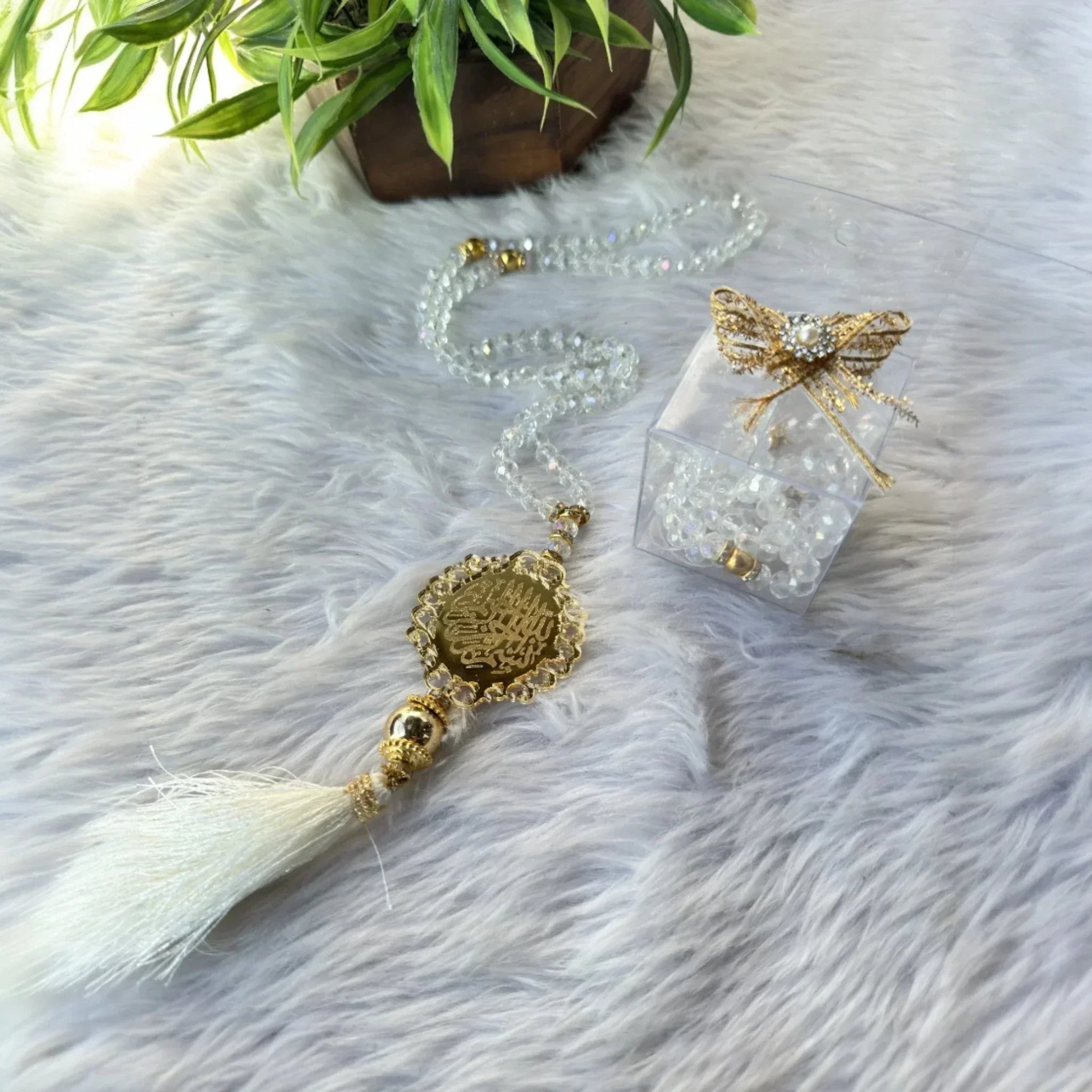 Elegant crystal Tasbeeh with gold accents and white tassel on fur rug