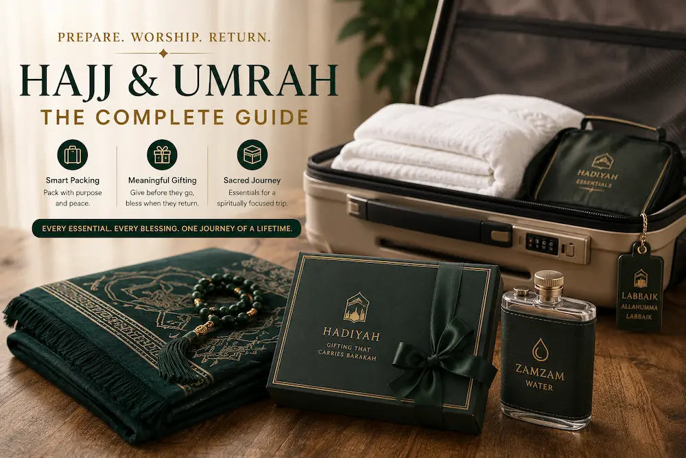 A clean, minimalist arrangement of an open travel suitcase, a folded hunter-green prayer mat, an elegant gift box, and a Zamzam flask, representing comprehensive preparation for a Hajj or Umrah journey