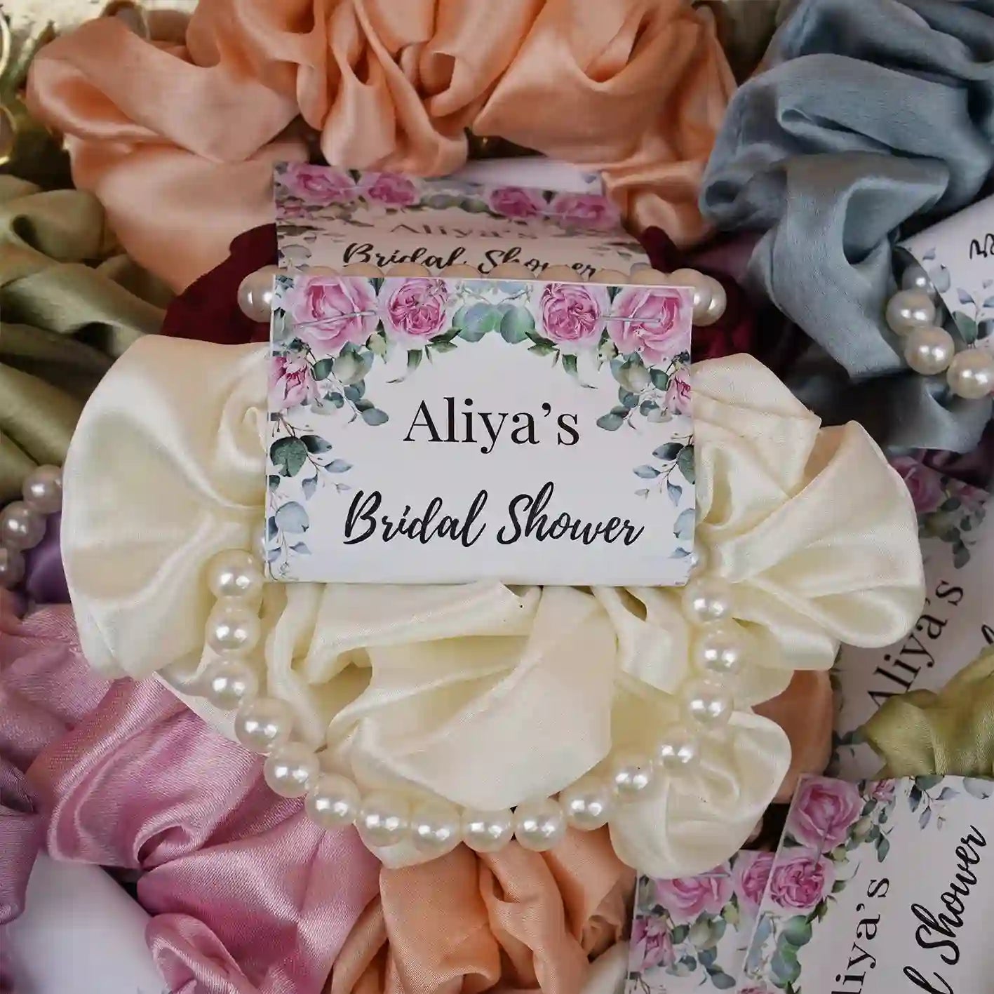 Noor Bridal Pearl & Silk Favors for bridal shower gift ideas, featuring ivory silk scrunchies with pearl bracelets and custom floral tags. Main image