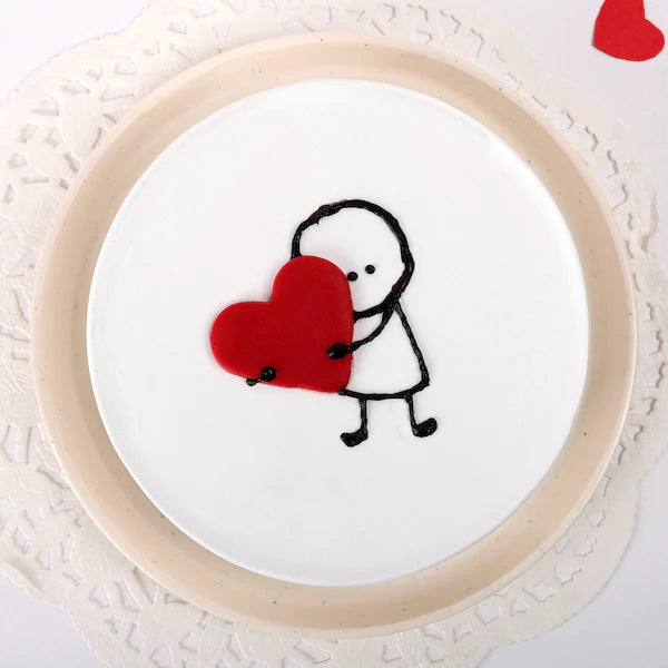 Heartfelt Vanilla Cake with cute stick figure holding red heart, perfect for anniversaries and love-filled celebrations. Soft, fluffy vanilla flavor. Main image