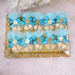 Gold tray with blue Aqiqah Golden Hearts Favors featuring gold heart chocolates and custom tags, ideal for baby or wedding favors.