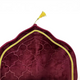 Maroon decorative pillow with gold embroidery on a white background