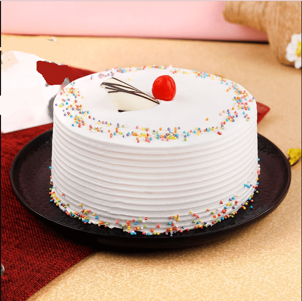 Vanilla Cake - Moist Delight with whipped cream frosting, decorated with rainbow sprinkles and cherry on top, ideal for same day delivery. Main image