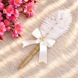 Golden pearl-beaded pen with a white satin bow, pearl embellishments and decorative feather for wedding favours.