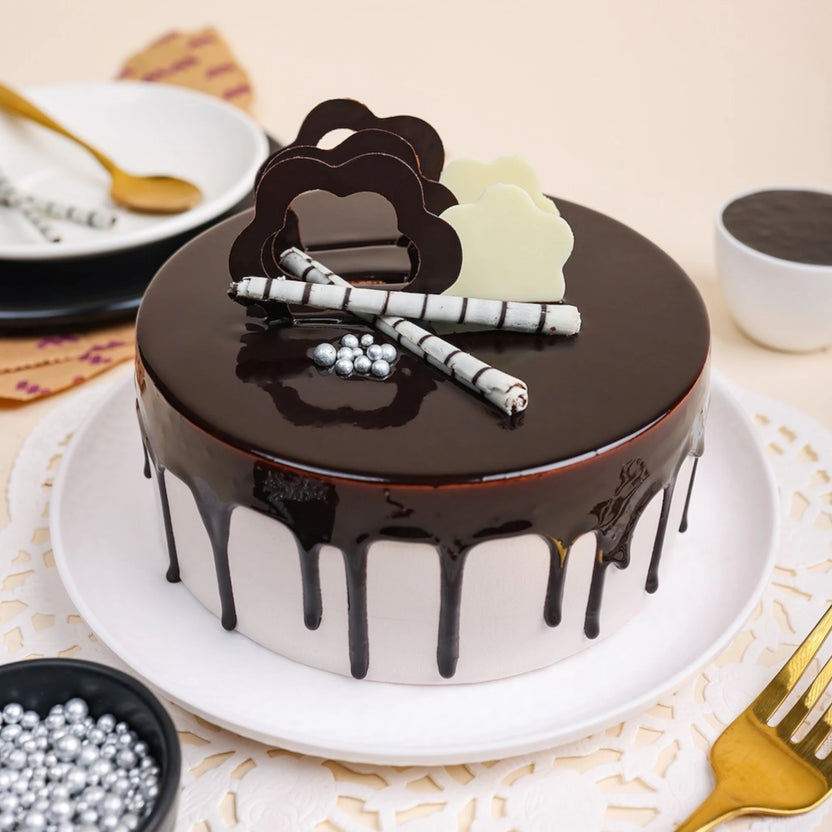 Mouth Melting Chocolate Cake - Indulgent Layers with glossy chocolate ganache, decorative chocolate clouds, and silver pearls on a white plate. Main image