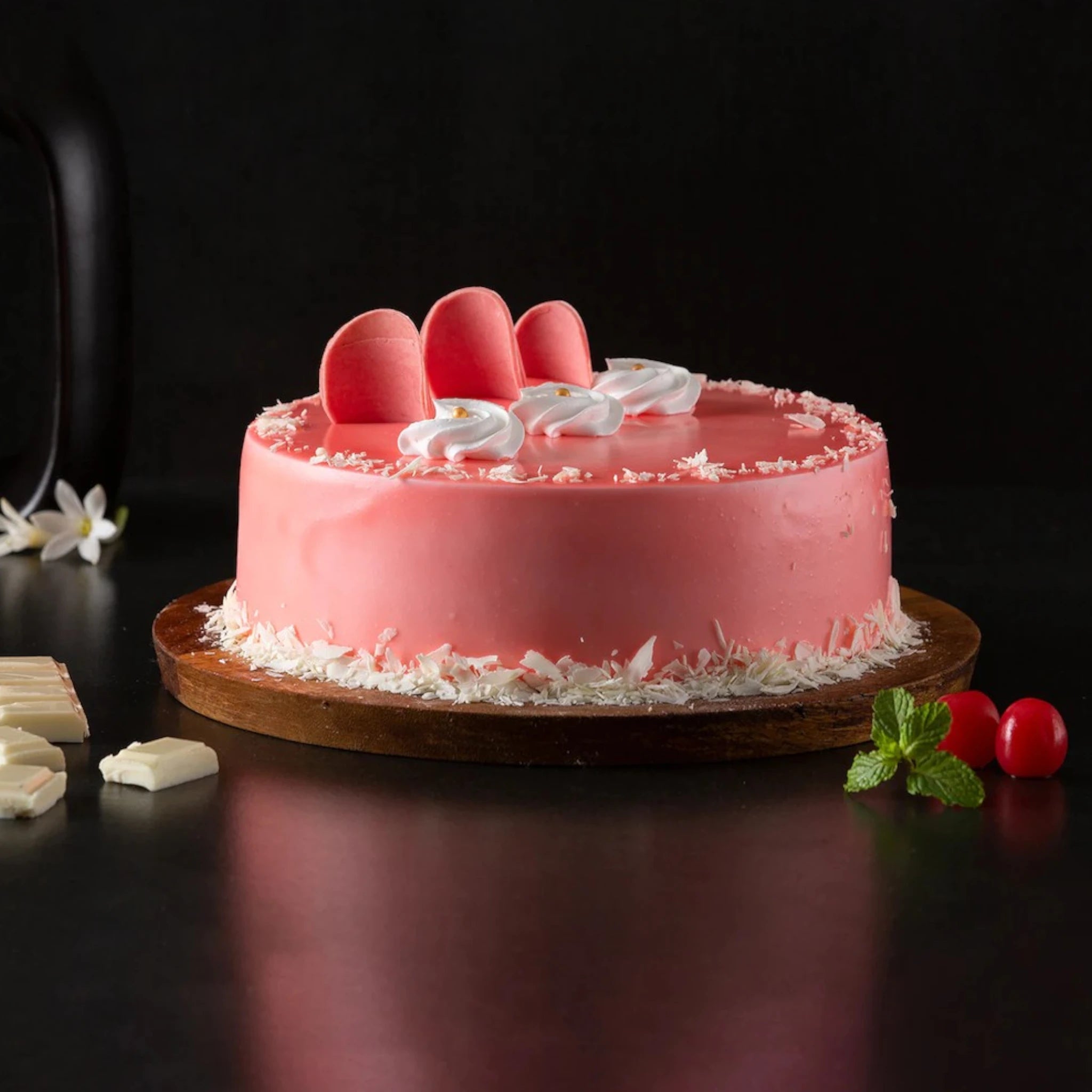 Fudge Cream Cake - Rich Layered Dessert | Chocolate Fudge with pink glaze, white cream swirls, and red macarons on a wooden base. Main image