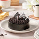 Fudge Brownie Cake with rich chocolate fudge topping and decorative chocolate shards on a white plate. Ideal for same day delivery chocolate cake gifts.