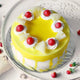 Top view of Delicious Pineapple Cake decorated with real pineapple chunks and cherries. A refreshing round cake for celebrations and gifting.