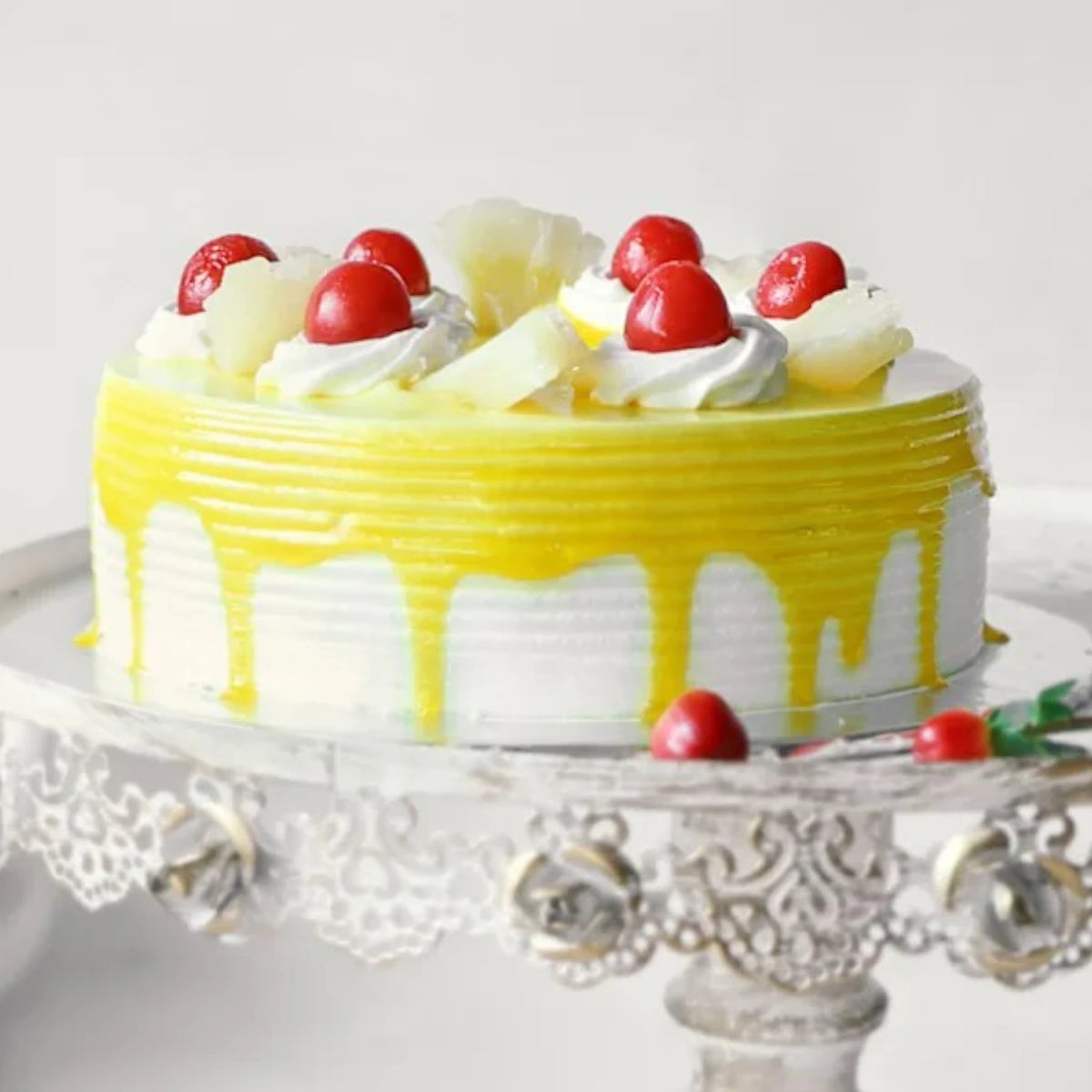 Side view of Delicious Pineapple Cake with yellow glaze, whipped cream, cherries, and pineapple chunks. Great for tropical flavor lovers.