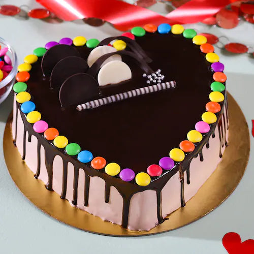 Colorful Gems Cake in heart shape with chocolate drip, rainbow sprinkles, and decorative toppings, perfect for celebrations and quick gifting.