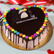 Colorful Gems Cake in heart shape with chocolate drip, rainbow sprinkles, and decorative toppings, perfect for celebrations and quick gifting.
