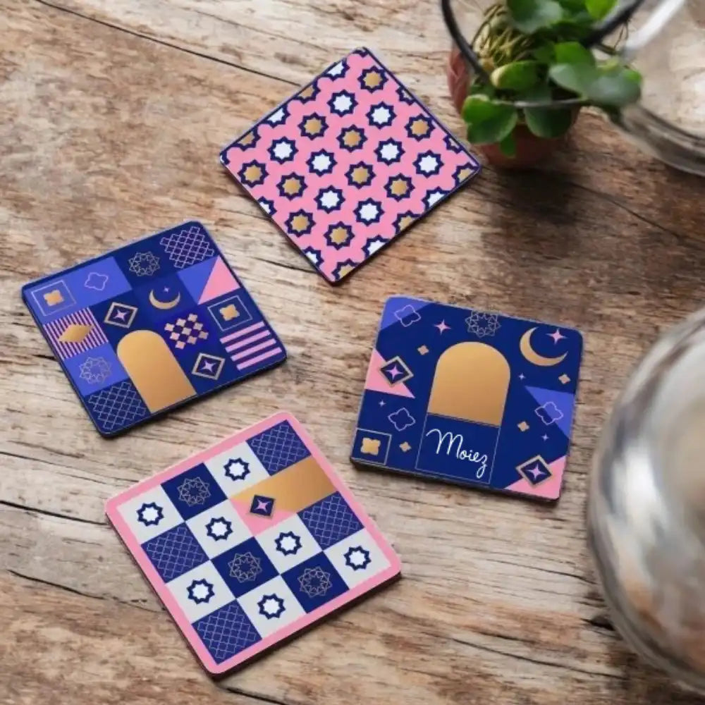 Four geometric patterned coasters on a wooden surface with a plant and glass container in the background. Main image
