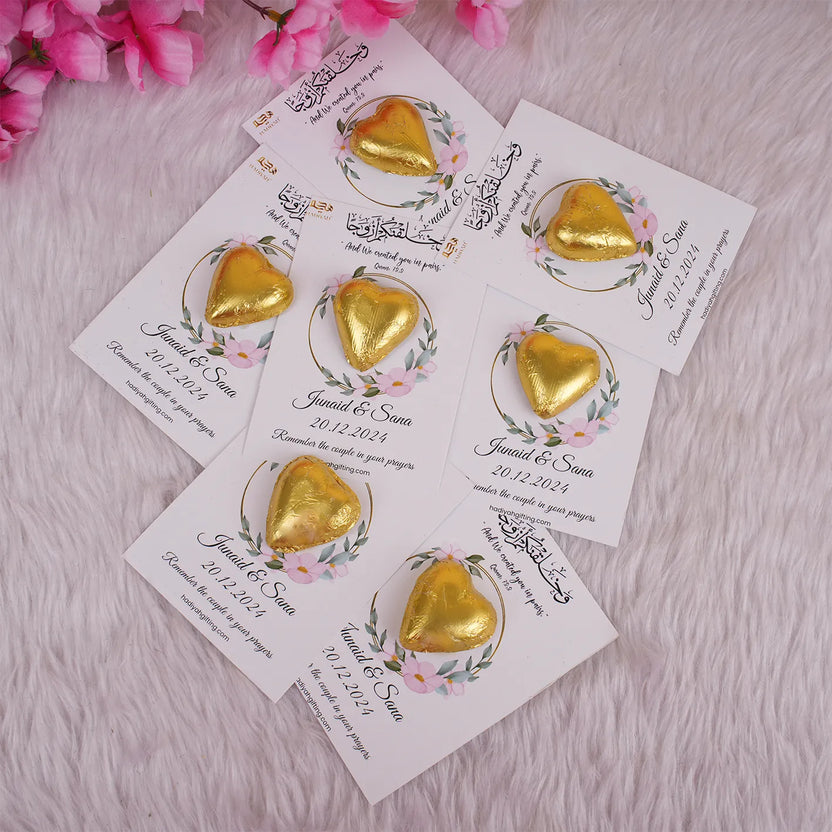Customized chocolate wedding favors for Nikah featuring gold heart-shaped chocolates on floral cards with Islamic quotes and couple's names. Main image