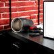 Personalized Not Your Habibi Sipper tumbler lying on its side near a laptop, showcasing stainless steel interior and detachable lid with red accent.