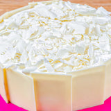 Close-up of Snow Sweet Whiteforest Cake featuring creamy white chocolate flakes and smooth vanilla layers, perfect for gifting and same day delivery.