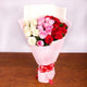 Elegant bouquet of red, pink, and white roses in pink wrapping with red ribbon, perfect for Women's Day or romantic celebrations.