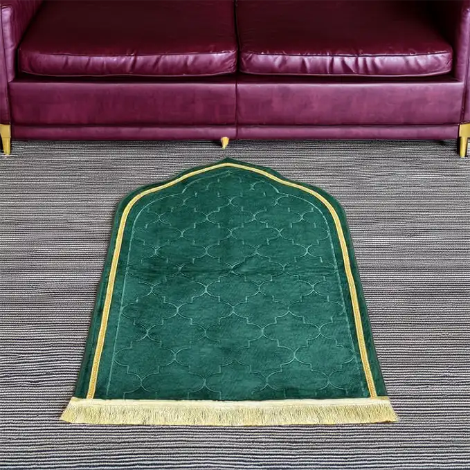 Green Dome Janamaz placed in front of a sofa, showcasing its dome shape and plush design for comfortable prayer sessions.