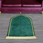 Green Dome Janamaz placed in front of a sofa, showcasing its dome shape and plush design for comfortable prayer sessions.