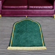 Green Dome Janamaz placed in front of a sofa, showcasing its dome shape and plush design for comfortable prayer sessions.