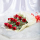 Classic Aura 12 Red Roses Bouquet - Perfect Gift laid flat, showcasing red roses with green and white fillers in soft cream wrapping and red ribbon.