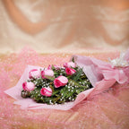 Elegant 8 Pink Roses Bouquet laid flat with greenery and white fillers, perfect for anniversaries or condolences. Shop same-day delivery gifts.