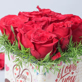Close-up of Red Roses Sticker Vase - You And Me showing vibrant red roses with green fillers in a decorative glass vase, perfect for romantic gifting.