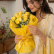 8 Yellow Roses arranged in packaging, close-up