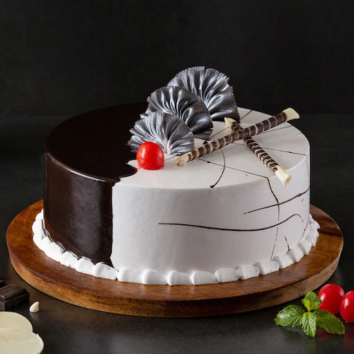 Choco Vanilla Cream Cake - Chocolate Vanilla Cake featuring half chocolate glaze, vanilla cream, chocolate sticks, and cherry, perfect for gifting.