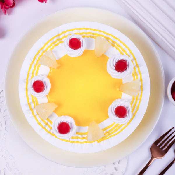 Top view of Sunshine Pineapple Cake featuring vibrant yellow glaze, red cherries, and pineapple slices on soft sponge layers for a tropical treat.