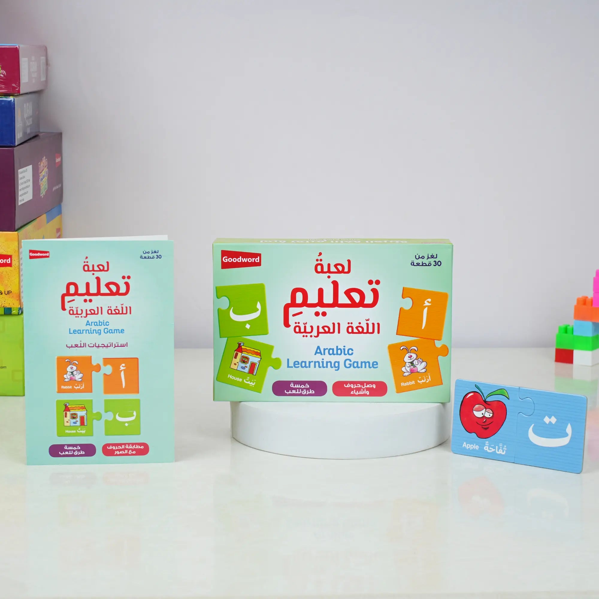 Children's Arabic learning game set on a white surface with colorful boxes in the background. Main image