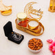 Decorative setup with candles, almonds, and 'Ramadan Mubarak' decoration on a light surface.