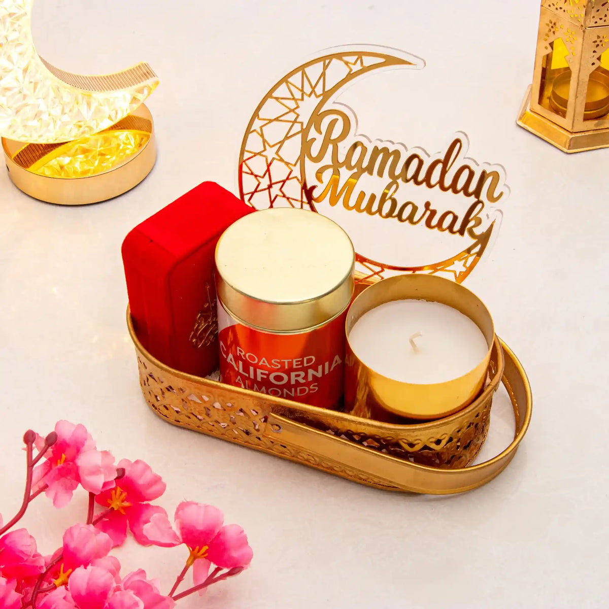 Decorative setup with candles, a box, and 'Ramadan Mubarak' sign on a light background.