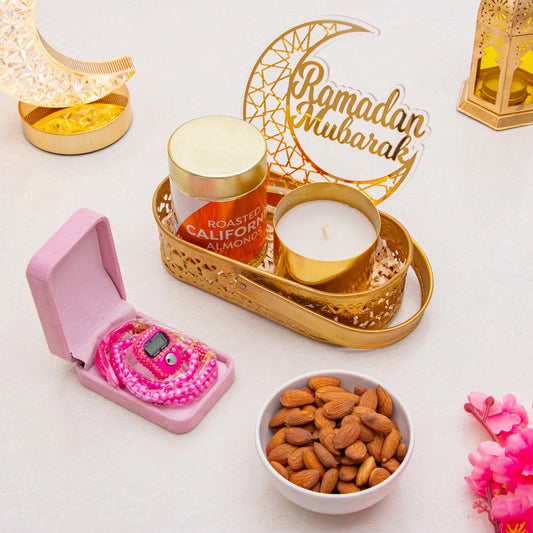 Ameen Luxe Ramadan Hamper with pink tasbih counter, roasted almonds, candle, and Ramadan Mubarak decor in a gold tray. Luxe Ramadan Gift Hamper.