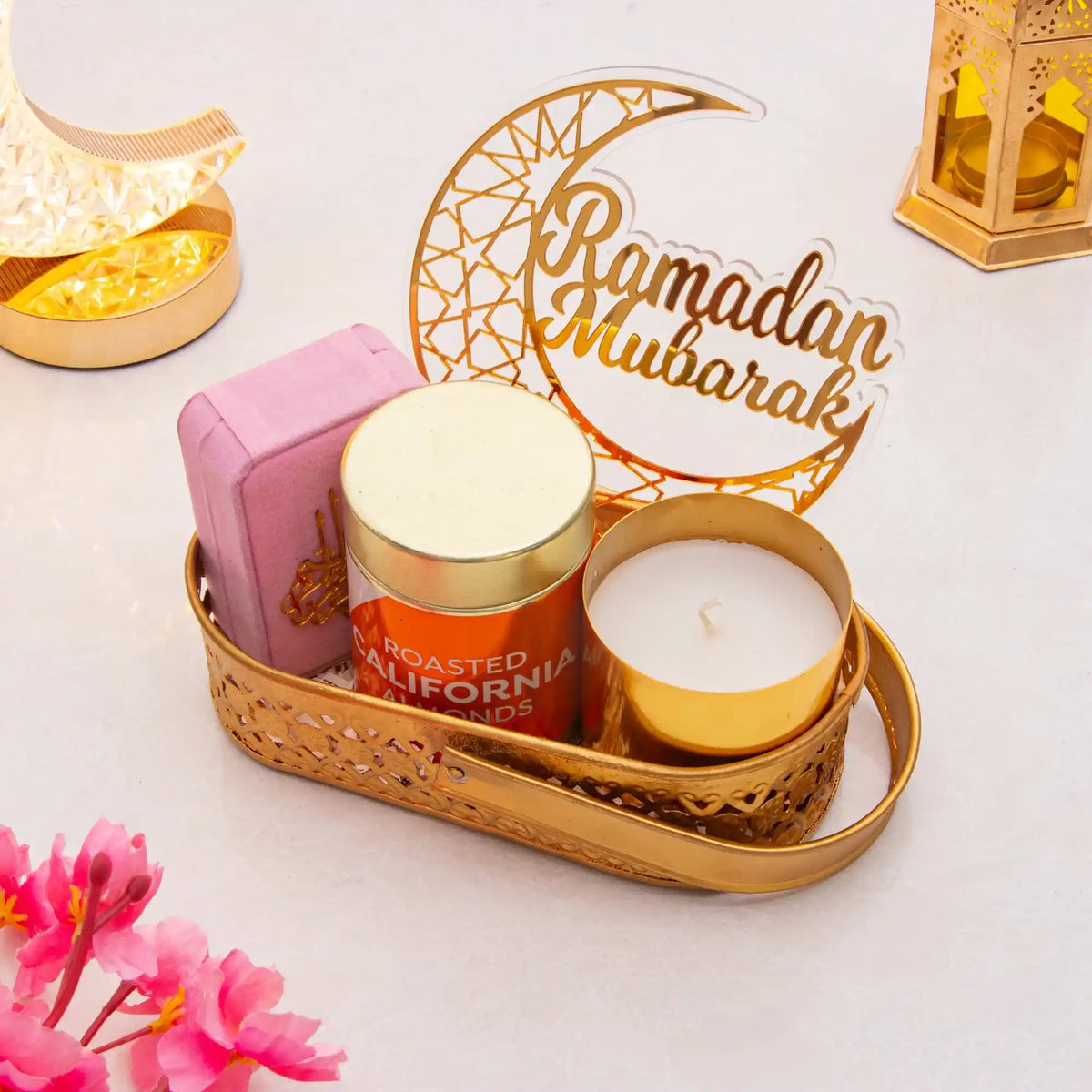 Decorative setup with candles, a 'Ramadan Mubarak' sign, and flowers on a light background