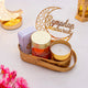 Luxe Ramadan Gift Hamper with white tasbih box, roasted almonds, candle, and Ramadan Mubarak crescent decor in gold tray. Elegant gift hamper.