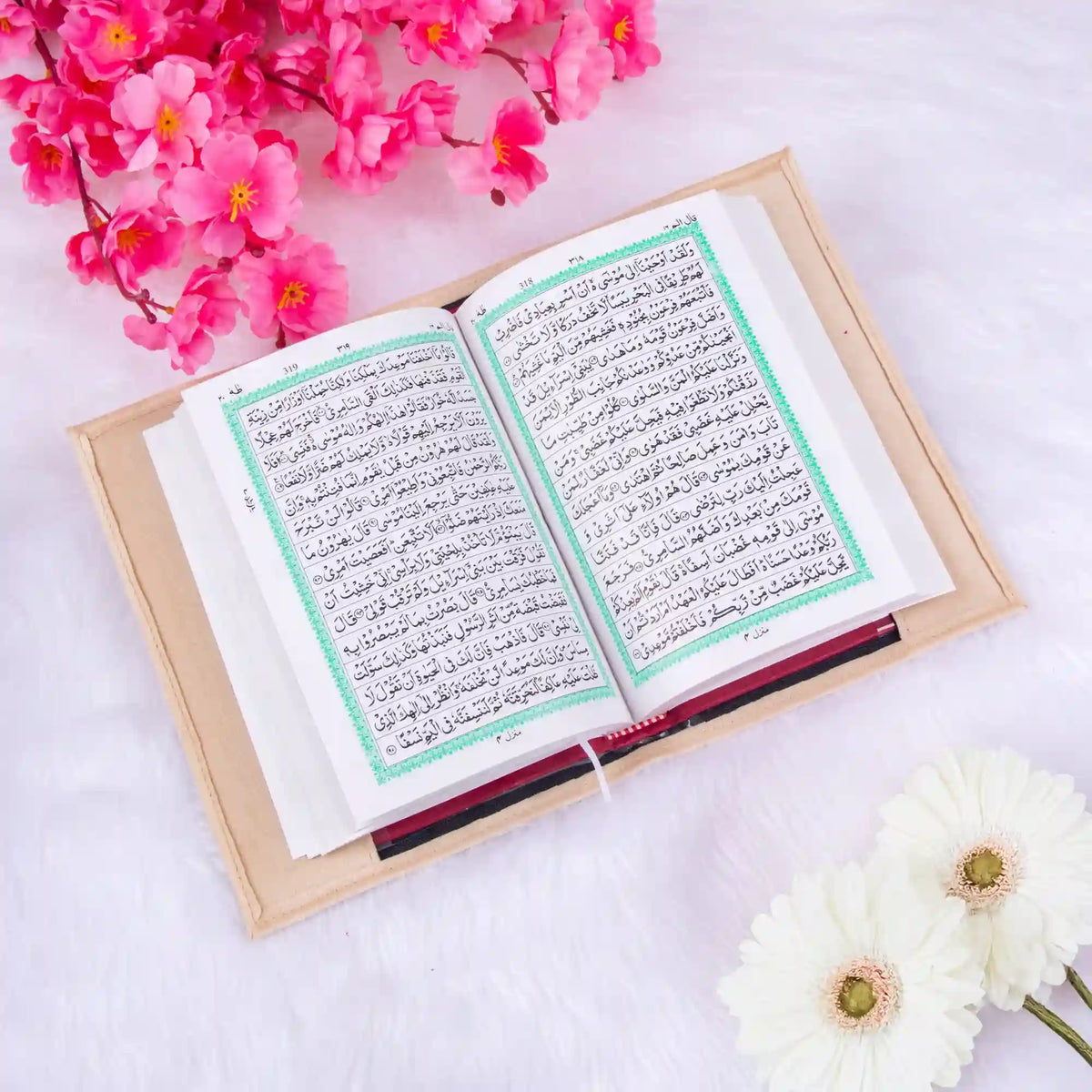 Open book with Arabic text on a light background with flowers