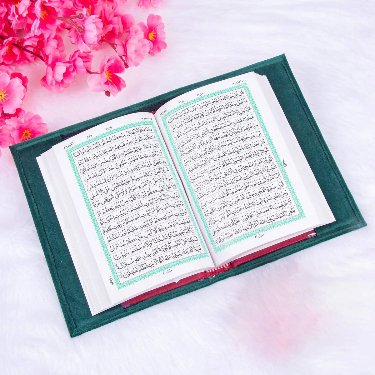 Open book with Arabic text on a white background with pink flowers