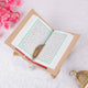 Quran with green border and Arabic script from the Rehal Bridal Hamper, includes a gold feather bookmark for ceremonial or bridal gifts.