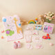 Baby Care Hamper - Baby Care kit with pink giraffe towel, embroidered babywear, grooming tools, and soft toys for newborn girls.