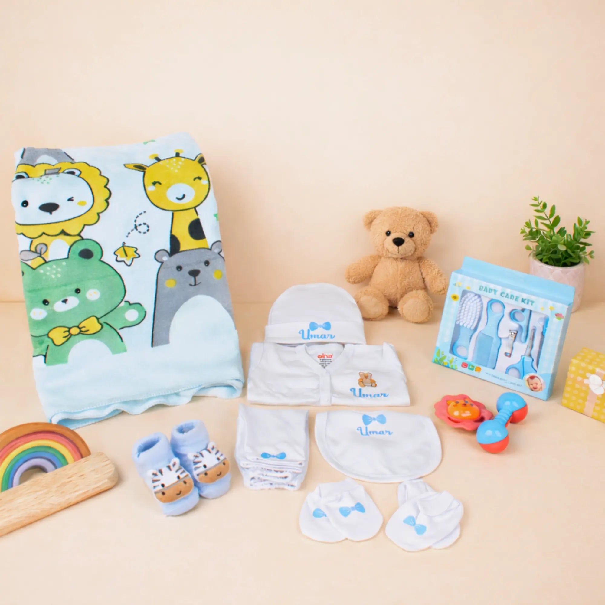 Baby Care Hamper - Baby Care set with blue animal print towel, grooming kit, personalized pyjama set, and soft toys for newborns. Main image