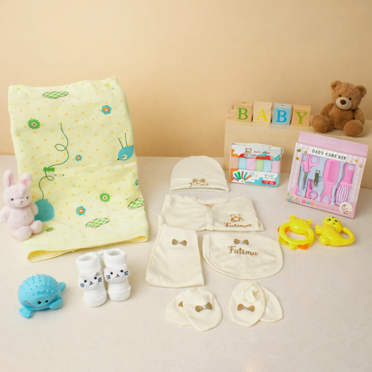 Baby Care Hamper - Baby Care gift set with yellow print towel, personalized baby clothing, grooming kit, and plush toys for toddlers.