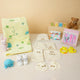 Baby Care Hamper - Baby Care gift set with yellow print towel, personalized baby clothing, grooming kit, and plush toys for toddlers.
