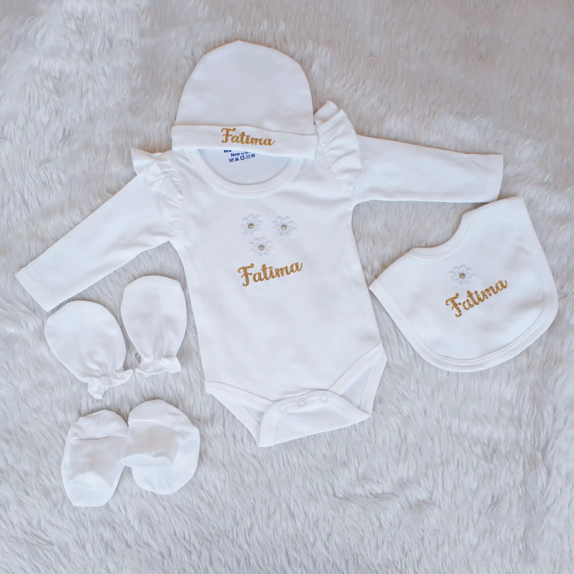 Baby clothing set with 'Fatima' embroidery on a soft surface