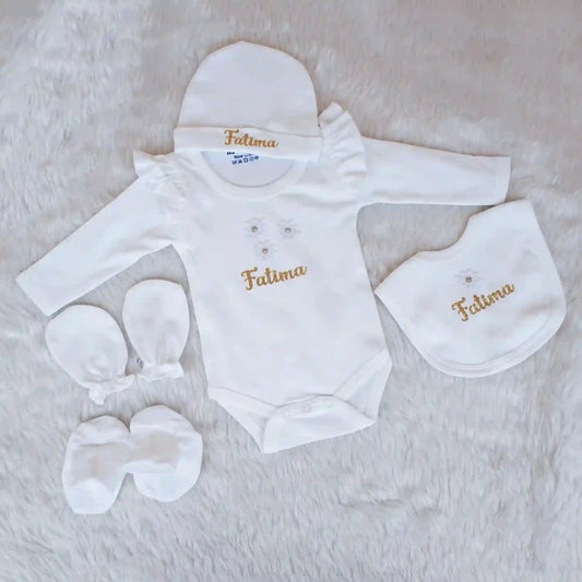 Baby clothing set with 'Fatima' embroidery on a soft surface