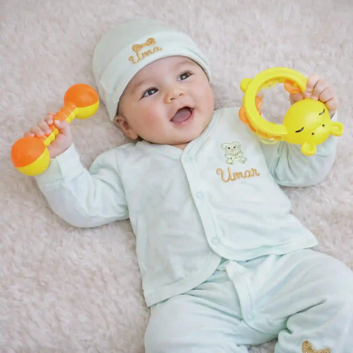 Personalized kids pyjama set for newborns in soft mint green with embroidered name 'Umar', includes matching cap, mittens, and bib for comfort.