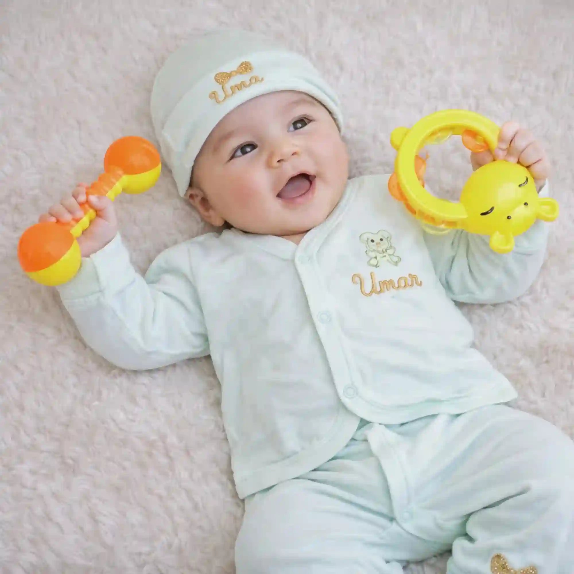Personalized kids pyjama set for newborns in soft mint green with embroidered name 'Umar', includes matching cap, mittens, and bib for comfort. Main image