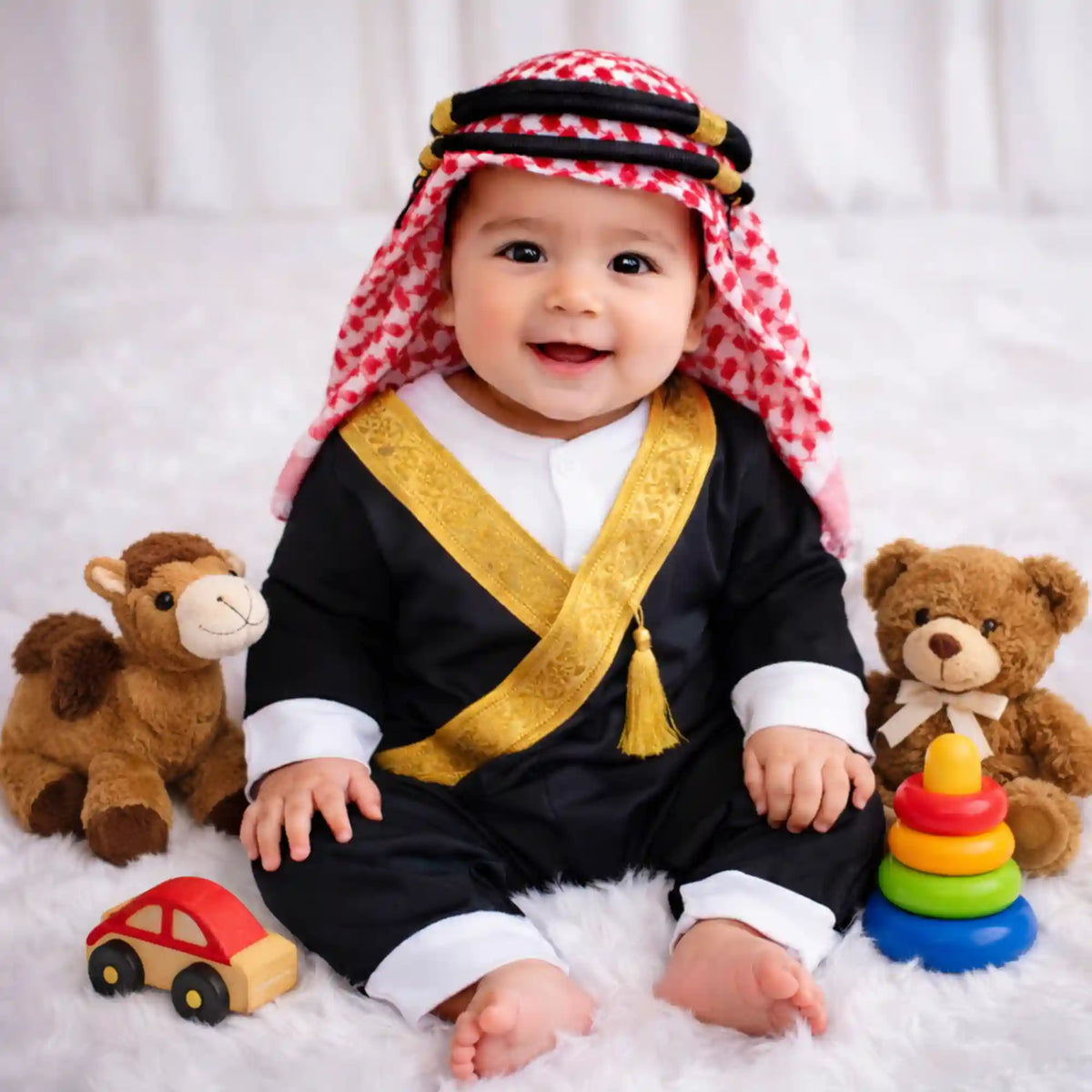 Baby boy in traditional attire with teddy bears and colorful stacking toys