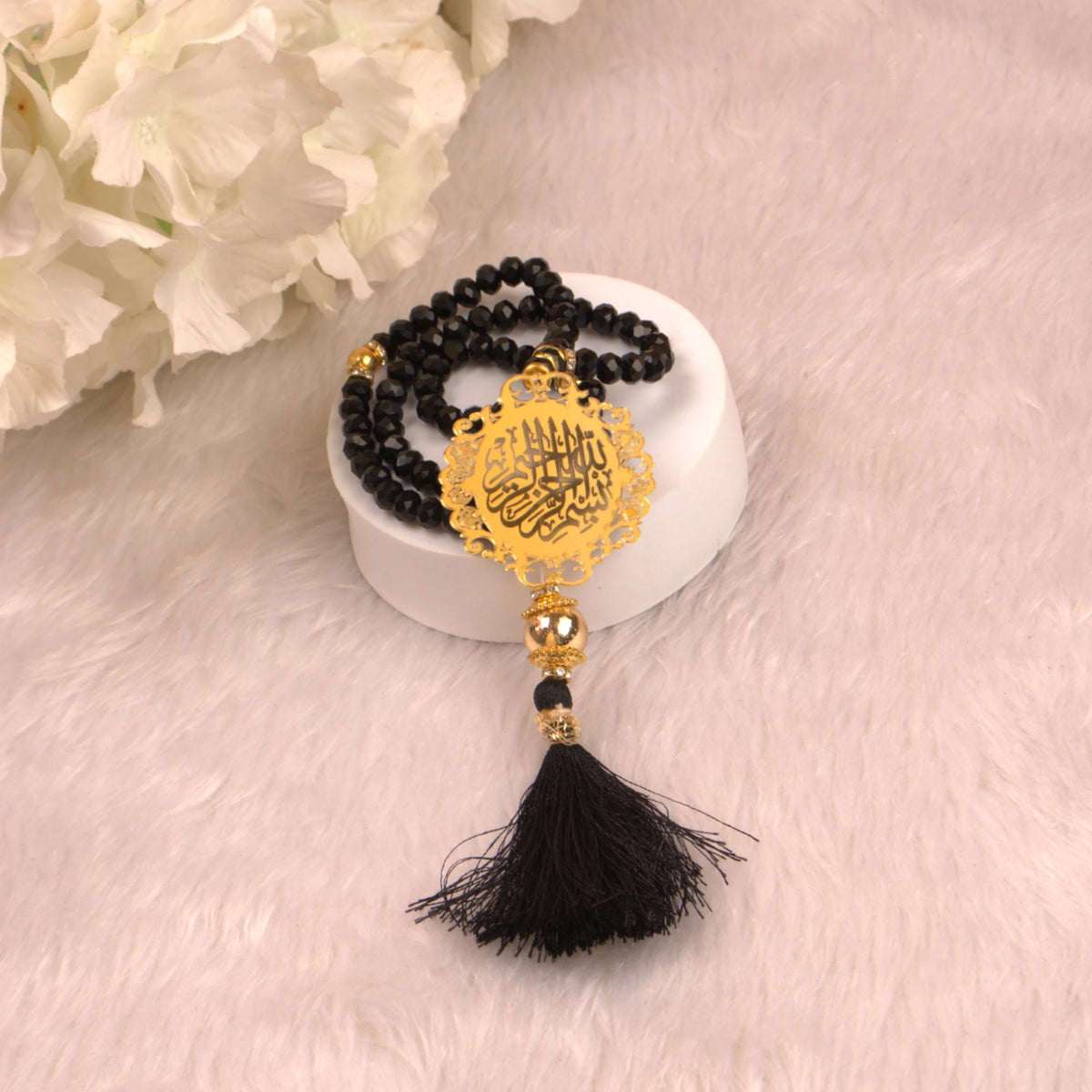 Black acrylic Tasbeeh with golden Islamic medallion and tassel from the Black Stones Rehal Hamper, perfect for daily dhikr and gifting.